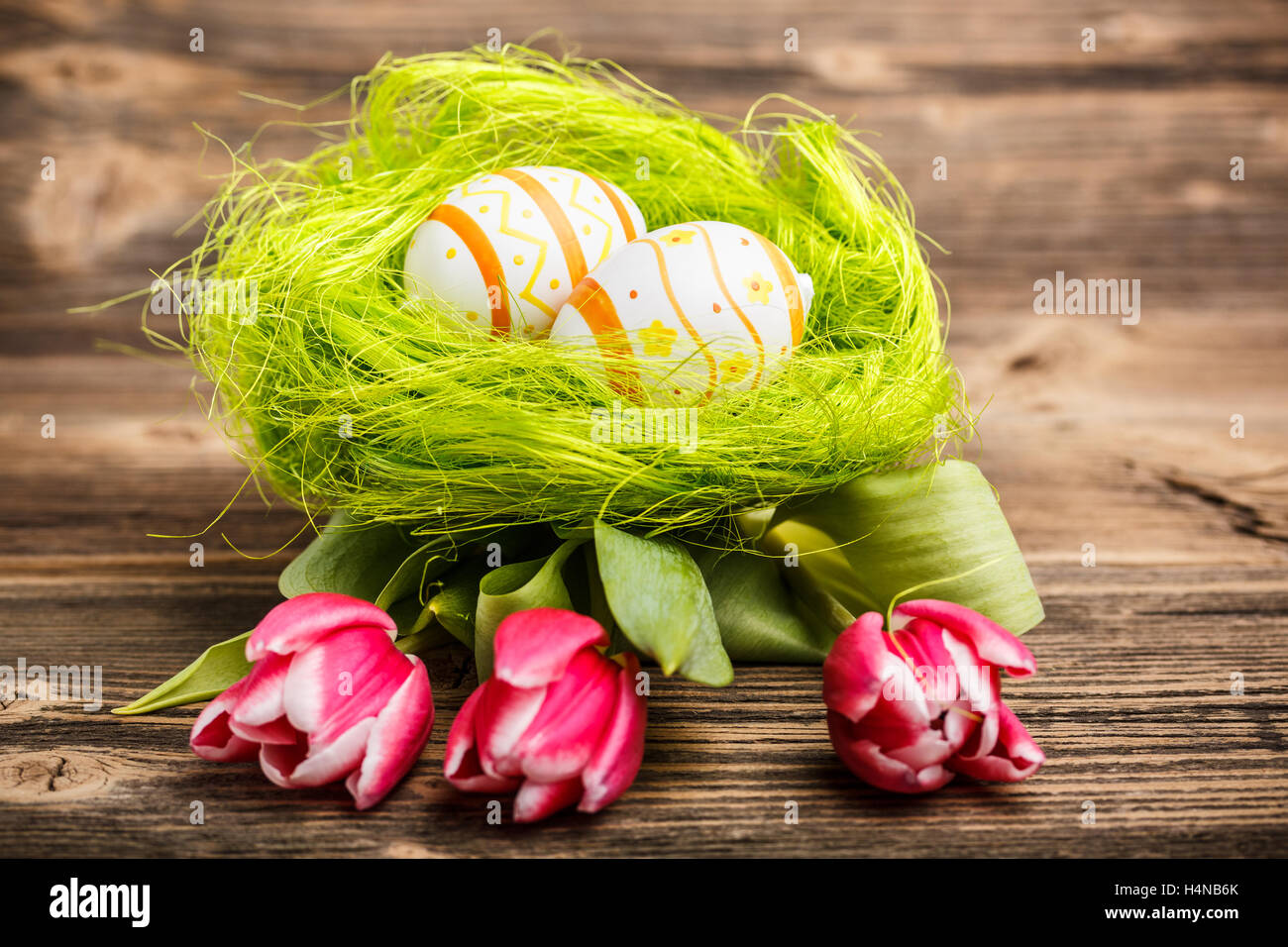 Easter eggs in a nest with tulips Stock Photo - Alamy