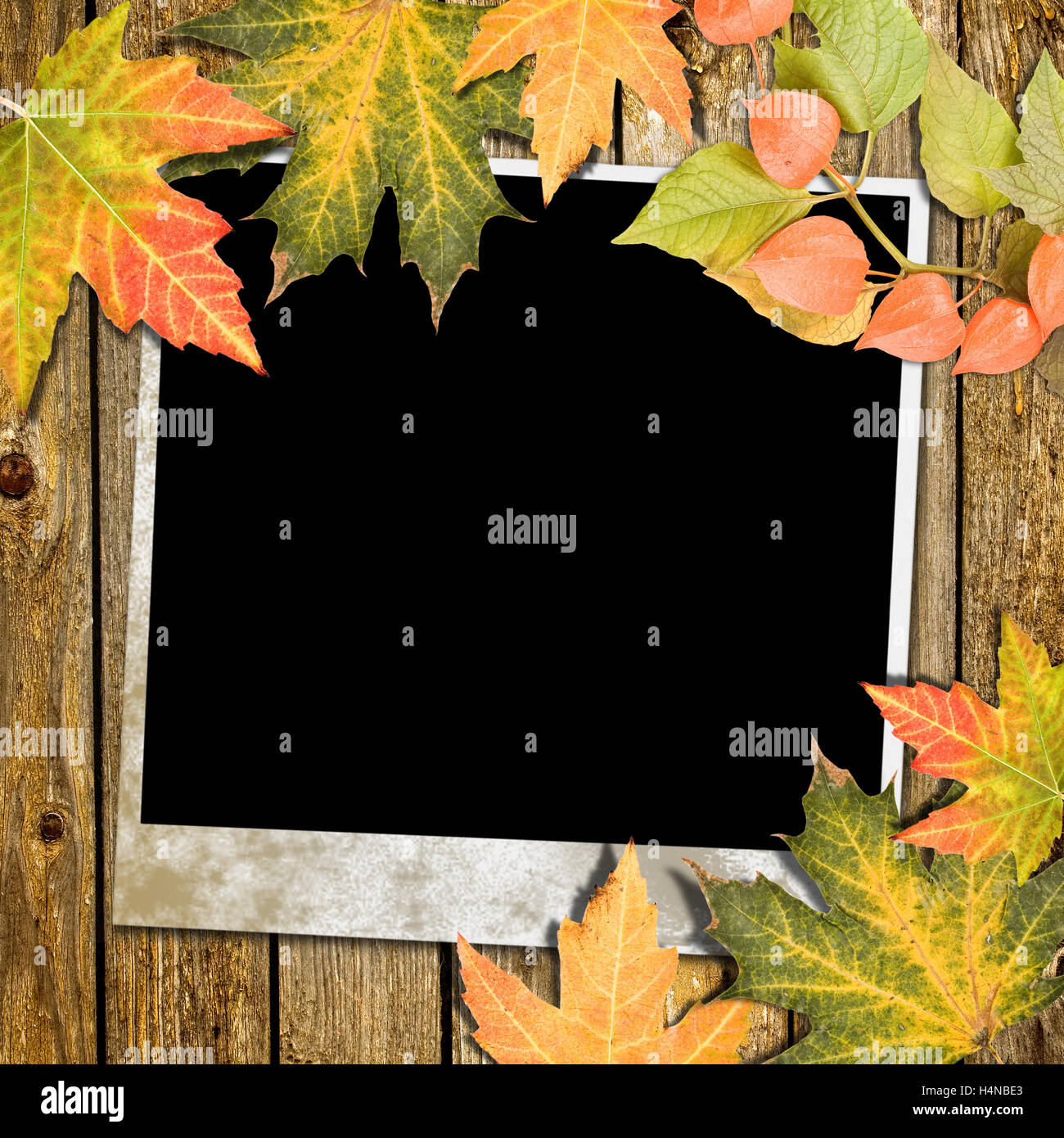 Autumn Leaves and photo frame over wooden background Stock Photo