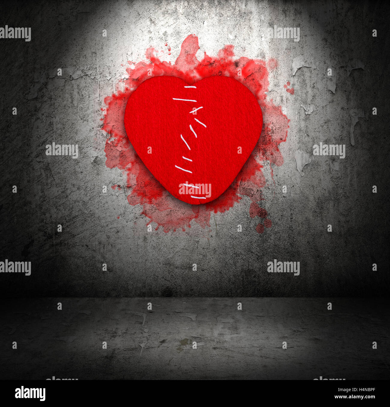 Stitched felt broken heart on old grunge obsolete wall with spotlight Stock Photo
