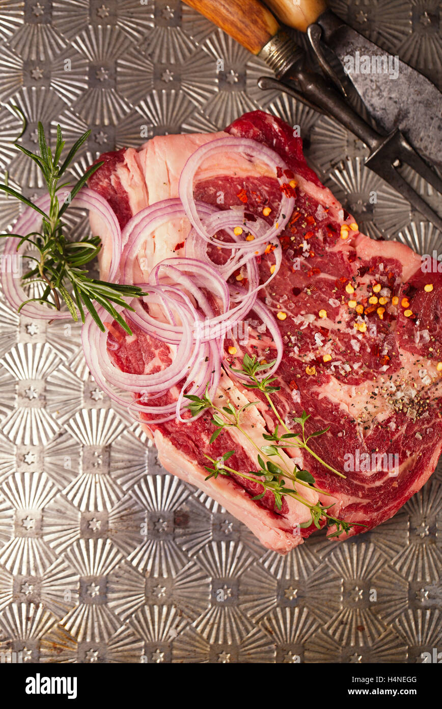beef steak tbone with vintage meat fork on metal backdrop Stock Photo
