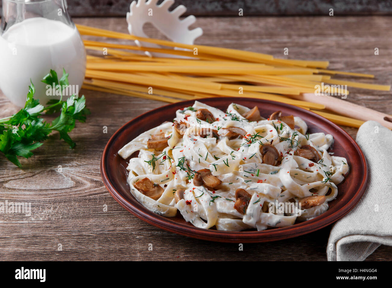 pasta with cheese and fried mushrooms in white sauce Stock Photo