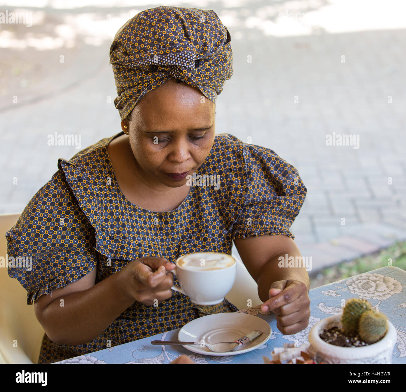 Portrait of an African women in traditional seshweshwe dress drinking