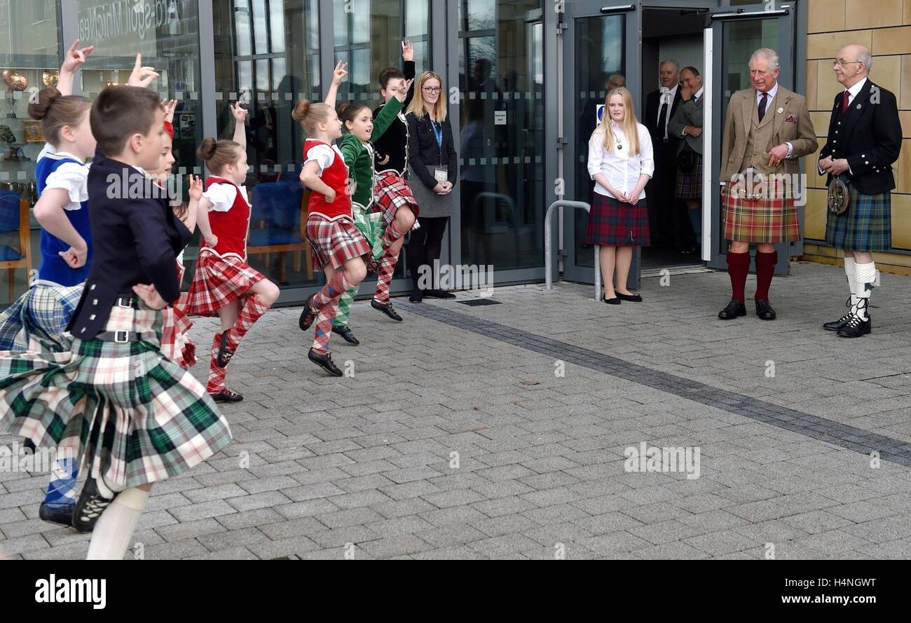 The Prince of Wales, known as the Lord of the Isles while in the Western Isles, and John Macleod, President of An Comunn Gaidhealach, watch young Highland dancers at the Nicholson Institute in Stornoway, Isle of Lewis. Stock Photo