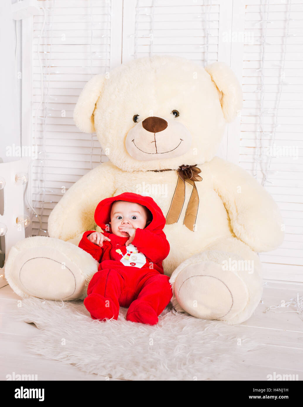 Cute baby with big teddy bear on white room Stock Photo - Alamy