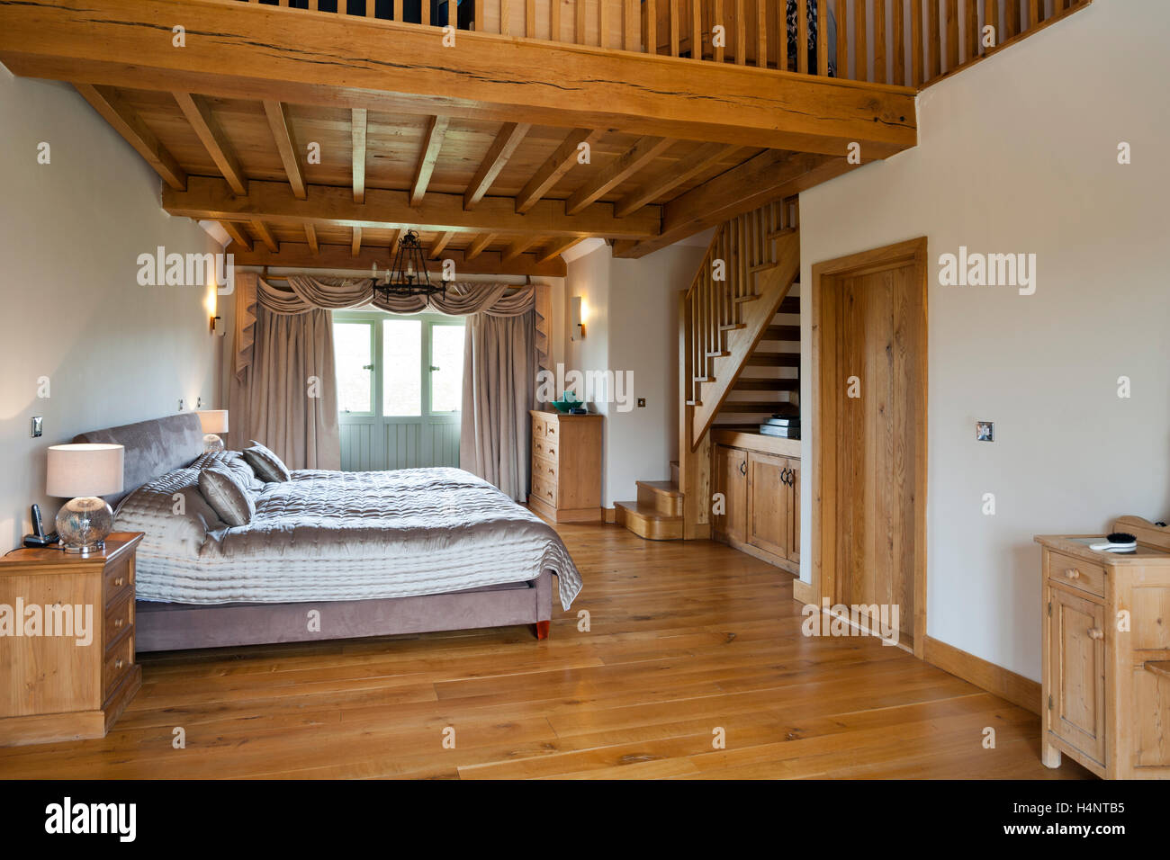 An upmarket barn conversion bedroom with mezzanine Stock Photo