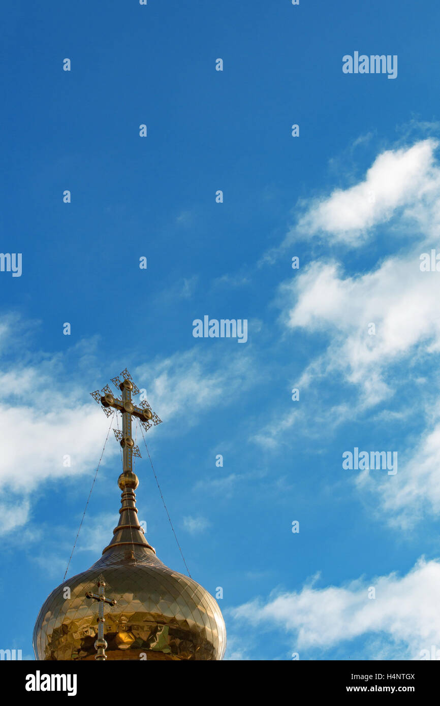 Golden dome of the Orthodox church with a cross on a background of blue ...