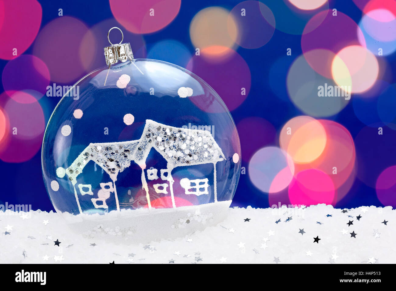 Transparent Christmas bauble on blue background with snow Stock Photo