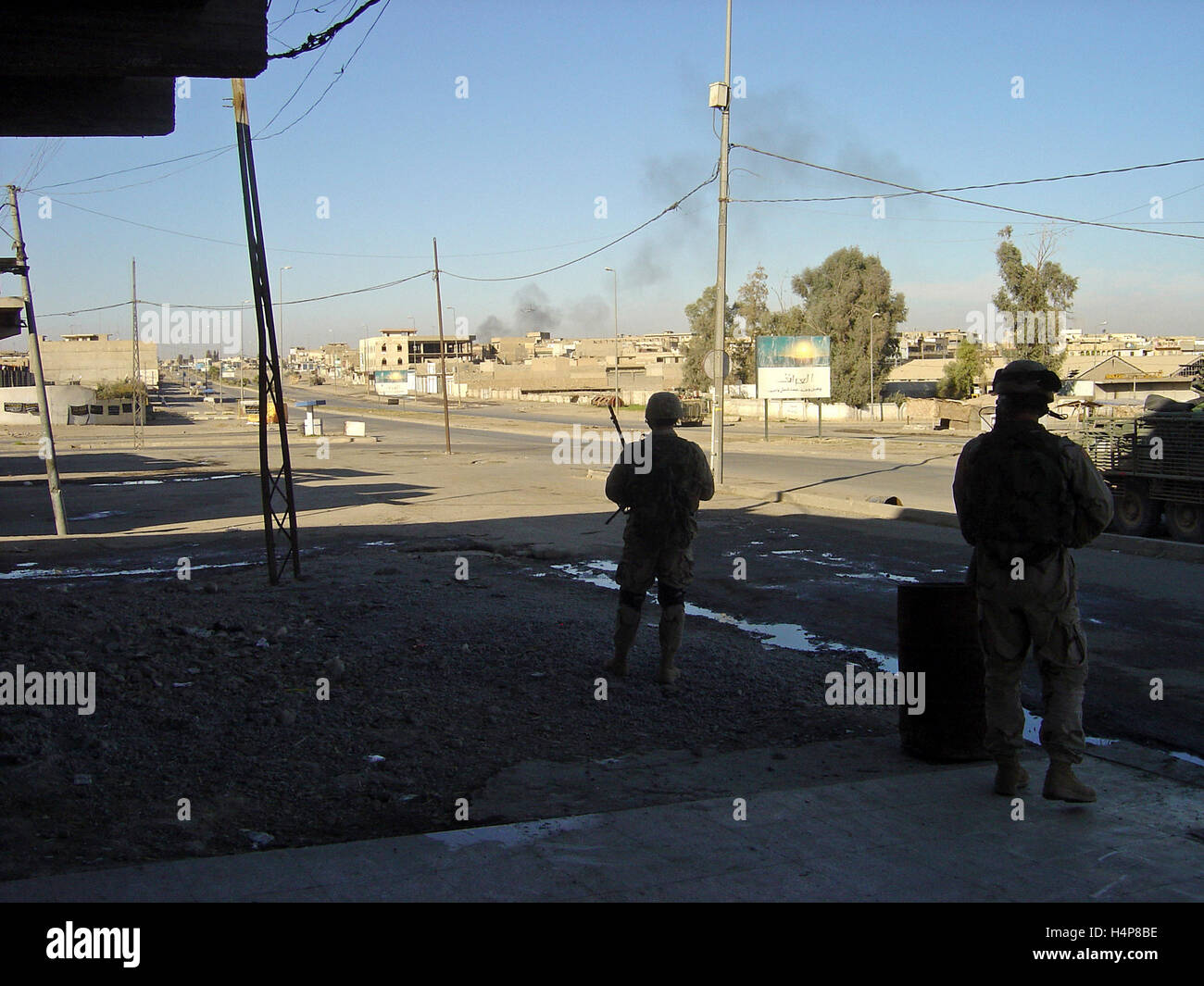3rd December 2004 U.S. Army soldiers on the streets of Mosul, Iraq, watch “Stryker” ICVs racing to join battle with insurgents ahead. Stock Photo