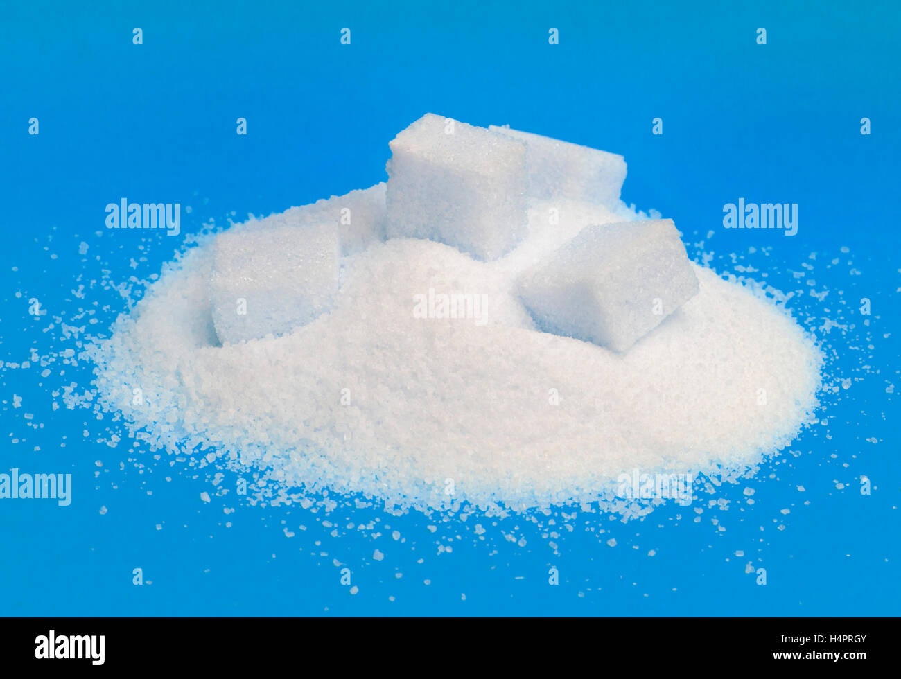 Pile of white sugar isolated on blue background Stock Photo