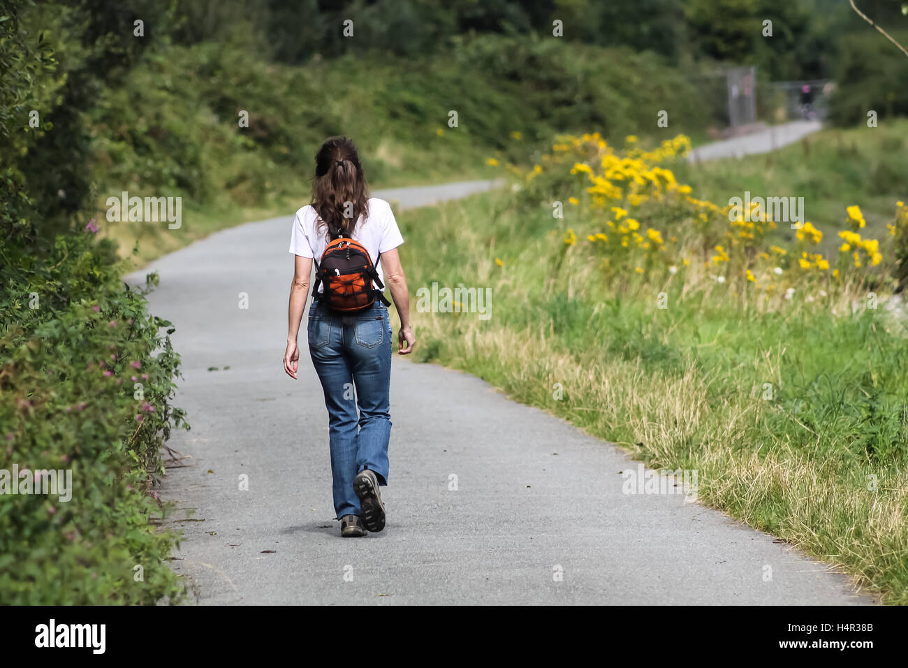 Girl walking on a country path Stock Photo - Alamy