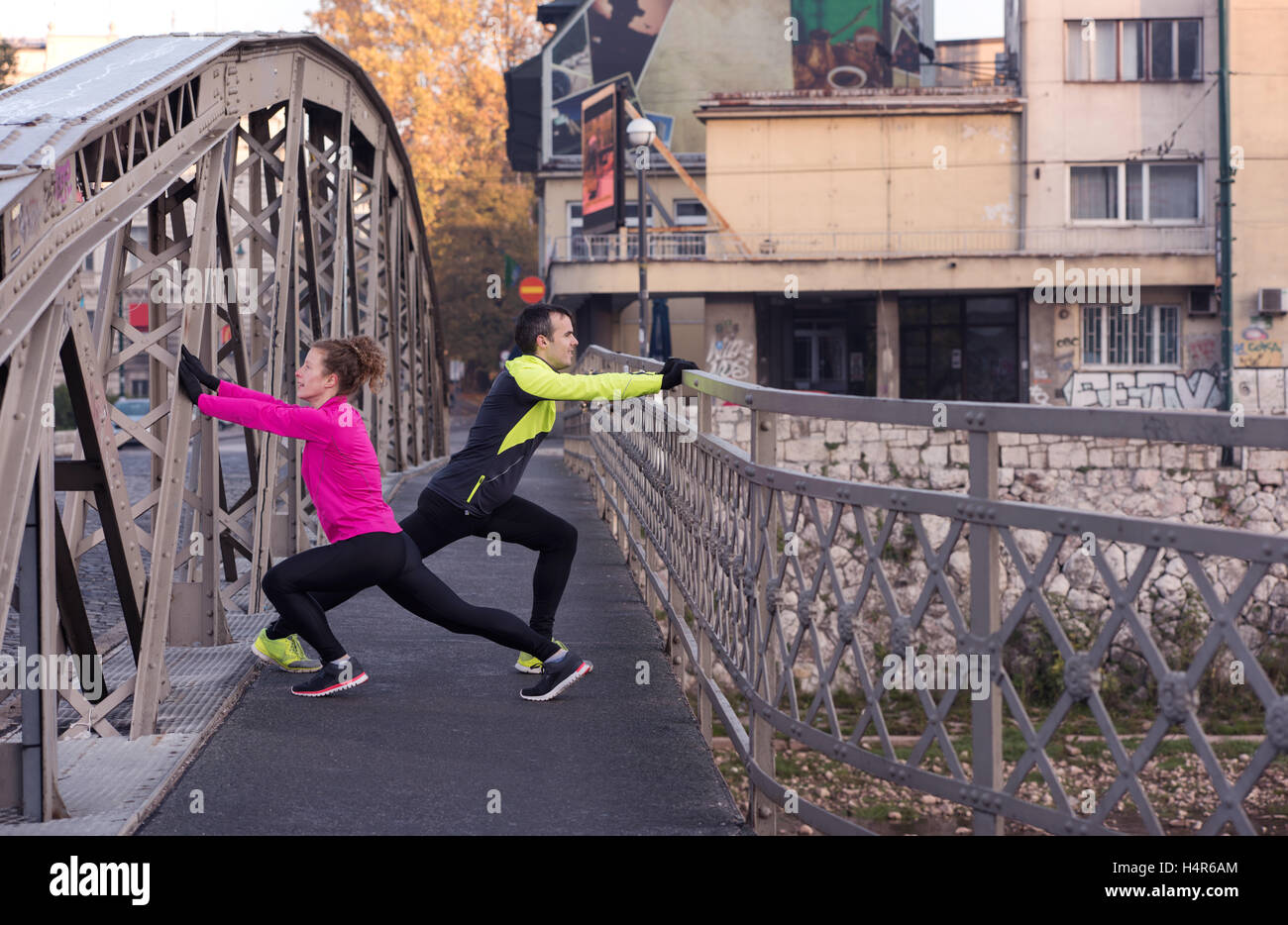 jogging couple warming up and stretching before morning running in the ...