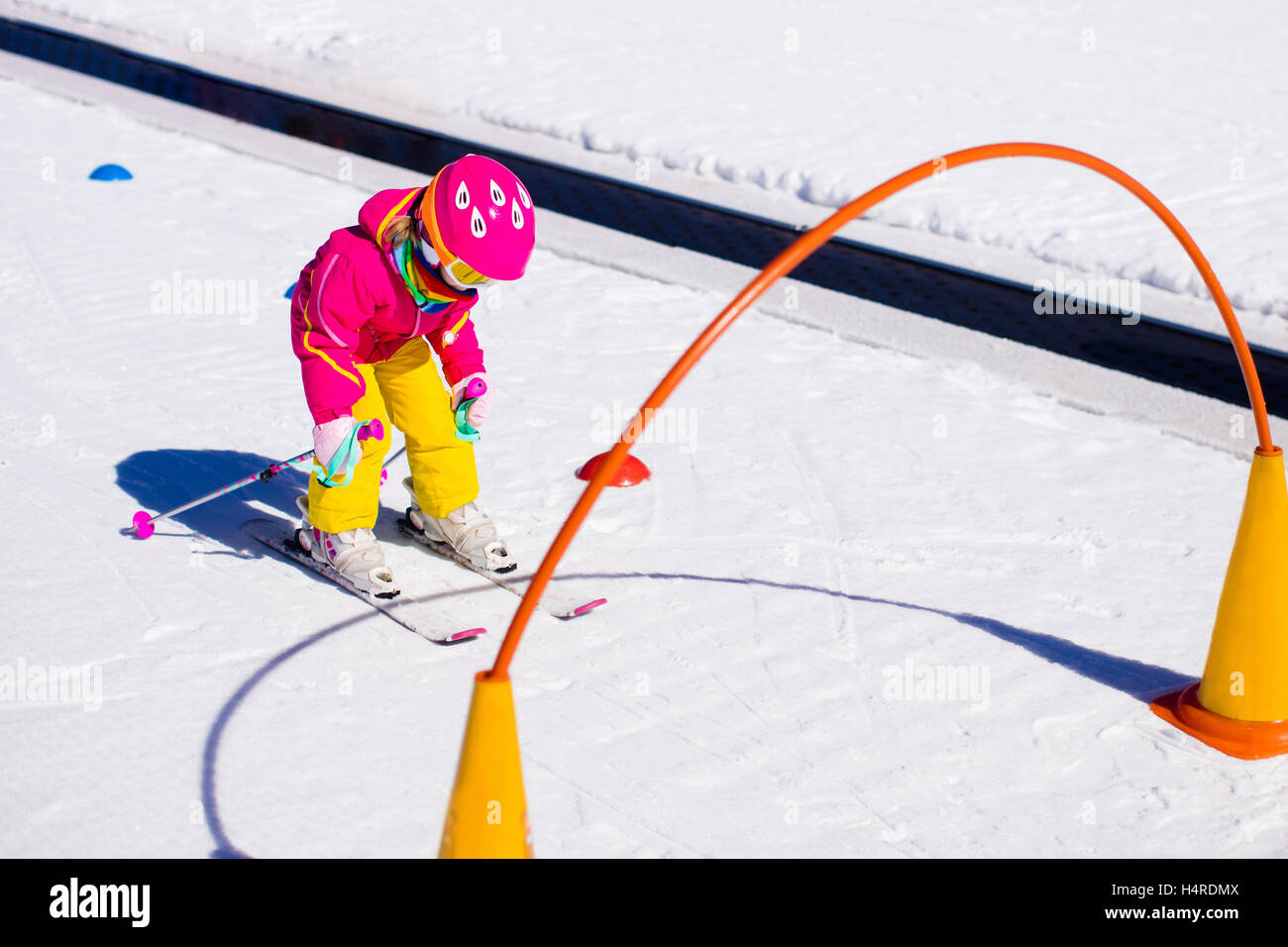 Child skiing in mountains. Active toddler kid with safety helmet