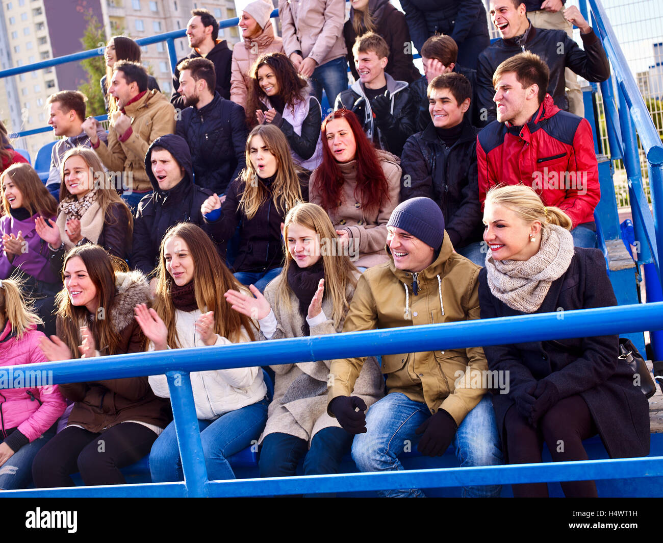 Sport fans clapping and singing on tribunes. Handrails in foreground Stock Photo Alamy