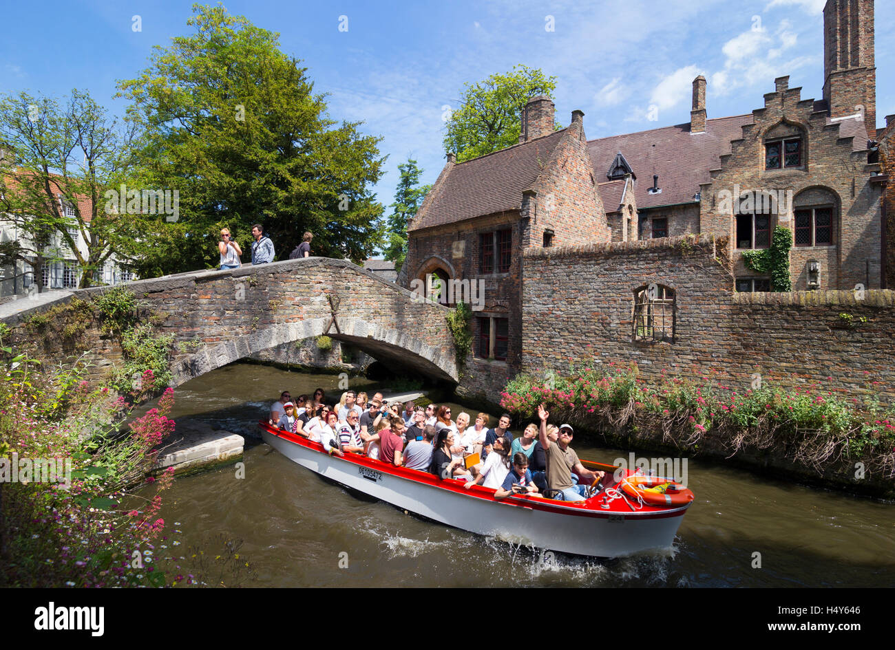 Bonifacius bridge and tourists taking a boat trip on the Bakkersrei canal, Bruges, Belgium Stock Photo