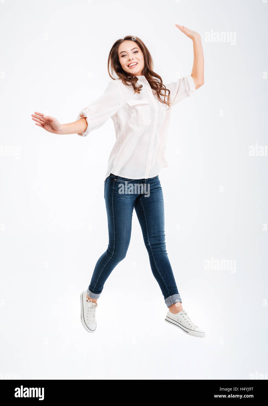 Full length portrait of a smiling pretty woman jumping isolated on a ...