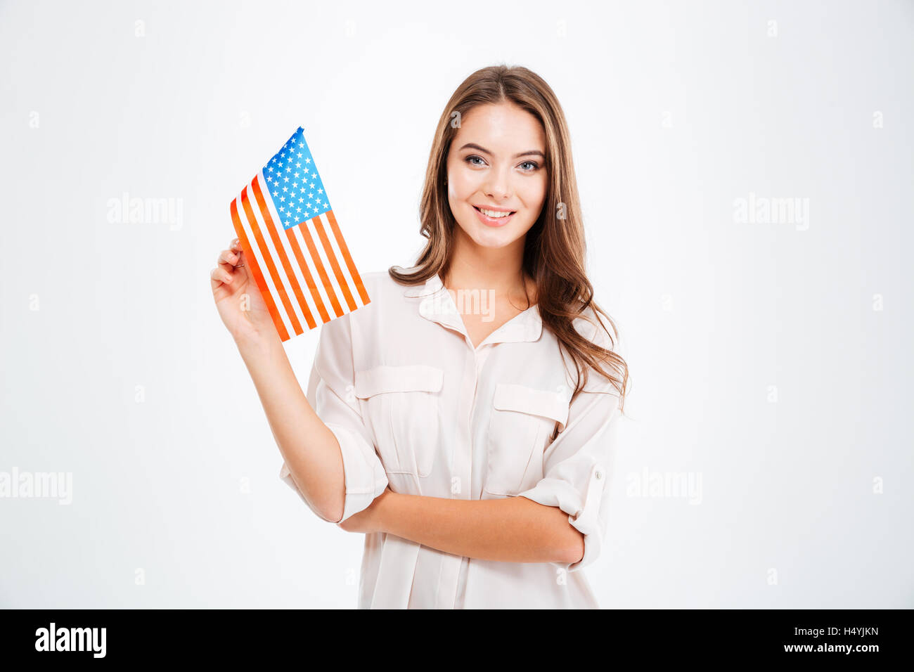 Portrait of a smiling young woman holding USA flag and looking at ...