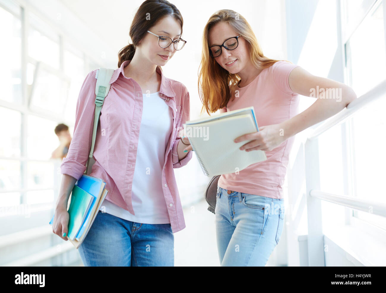 College students discussing lecture notes after lesson Stock Photo