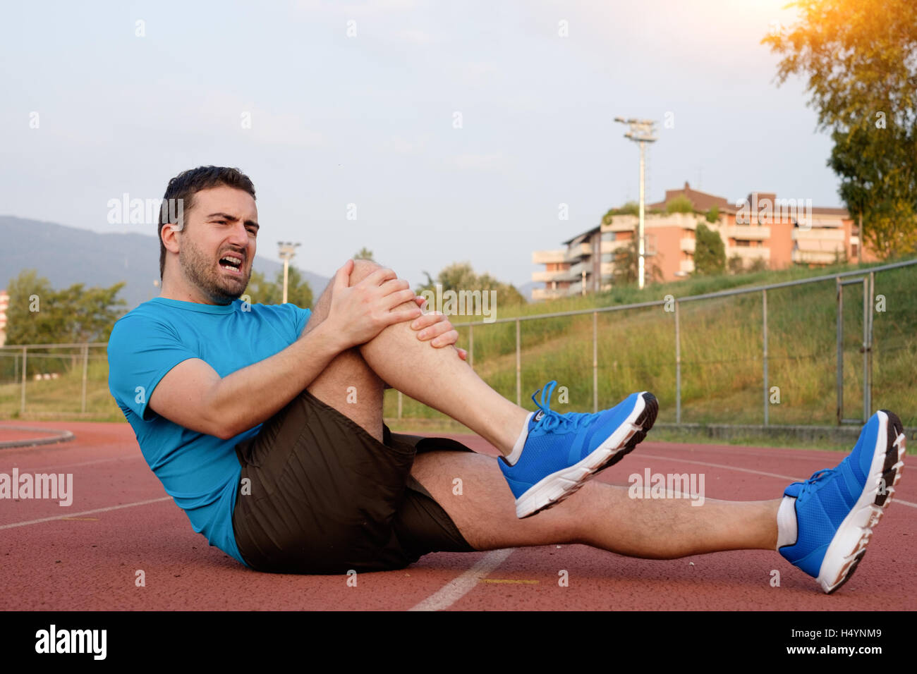 Runner with injured knee on the track Stock Photo