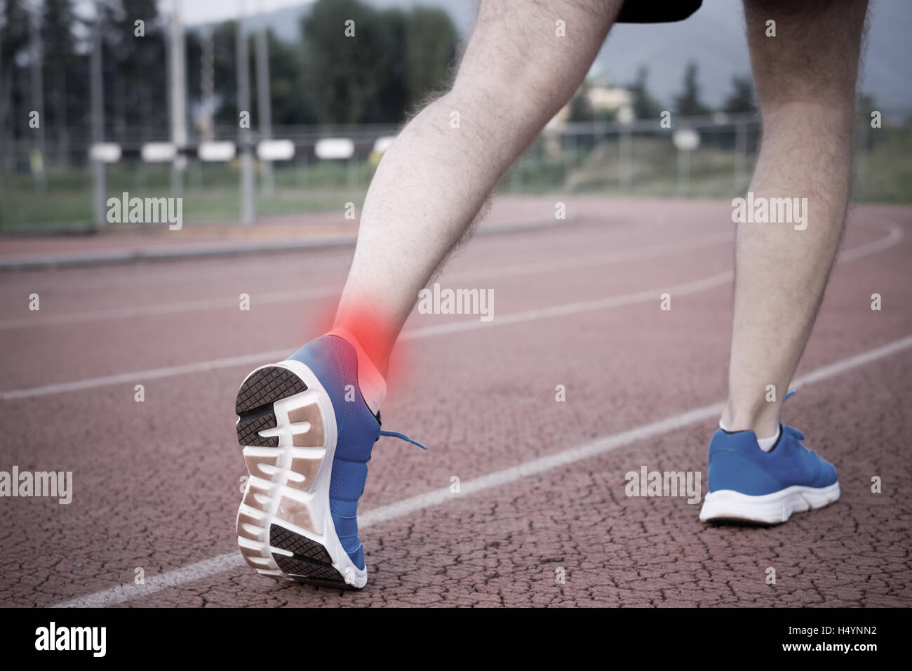 Runner with injured ankle on the track Stock Photo