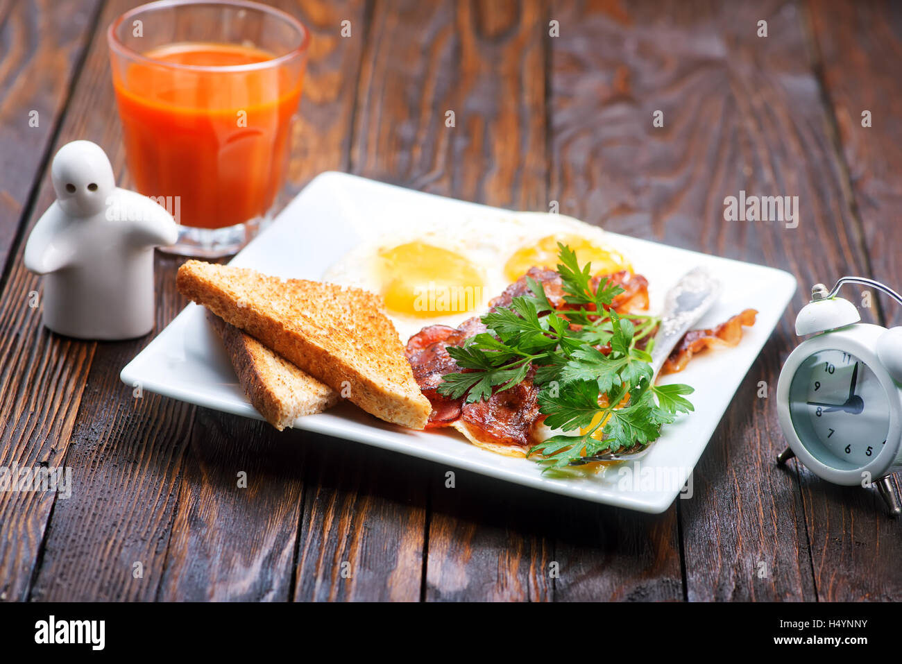 Breakfast on a table, fried bacon and eggs on plate Stock Photo Alamy