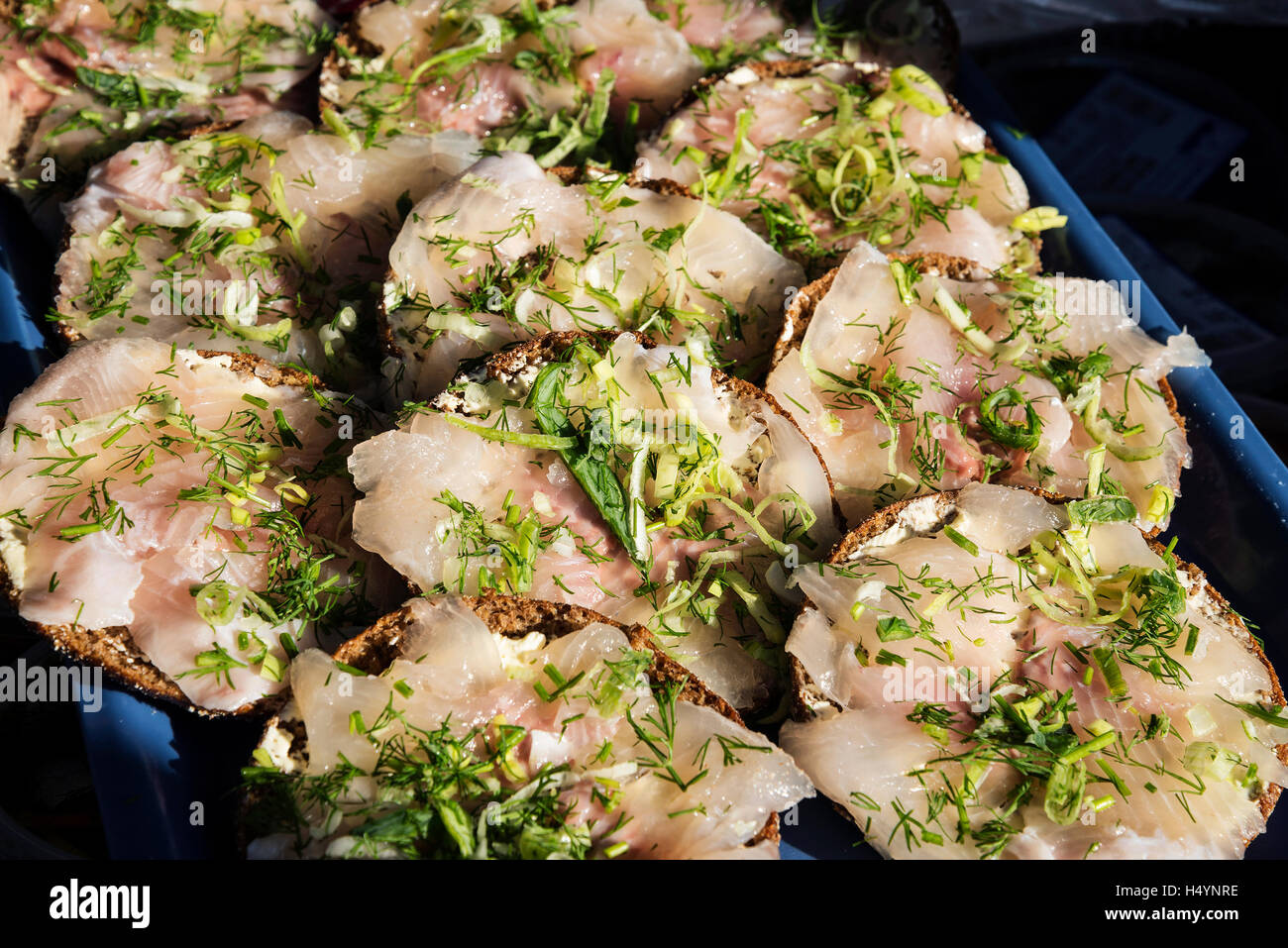 fresh marinated smoked scandinavian herring fish fillet mini sandwich snacks with dill in helsinki finland market Stock Photo