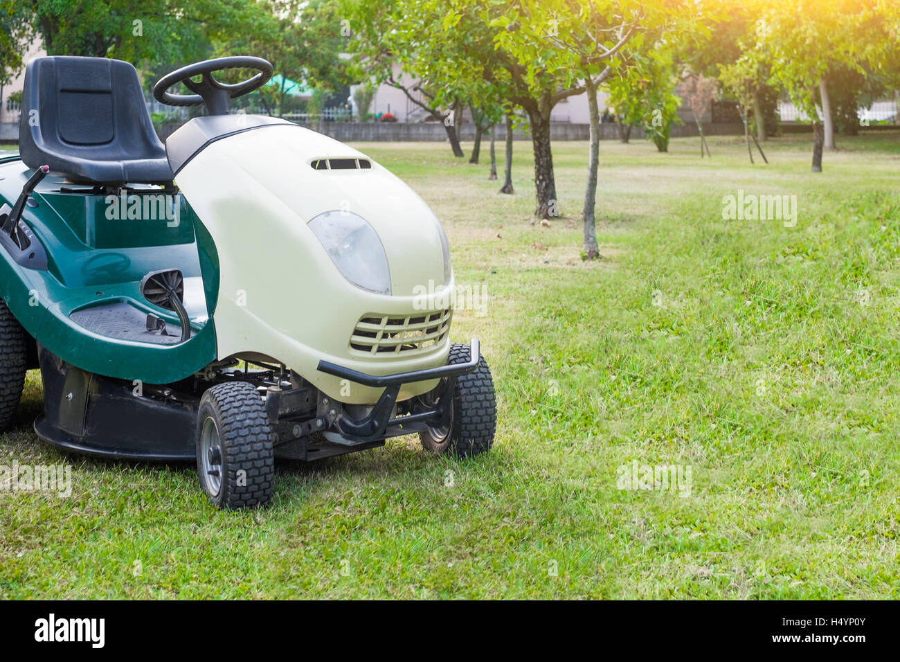Lawn mower parked in a garden Stock Photo