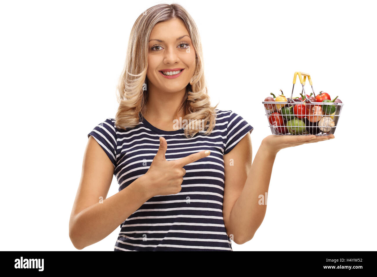 Joyful woman holding a small shopping basket full of fruits and ...