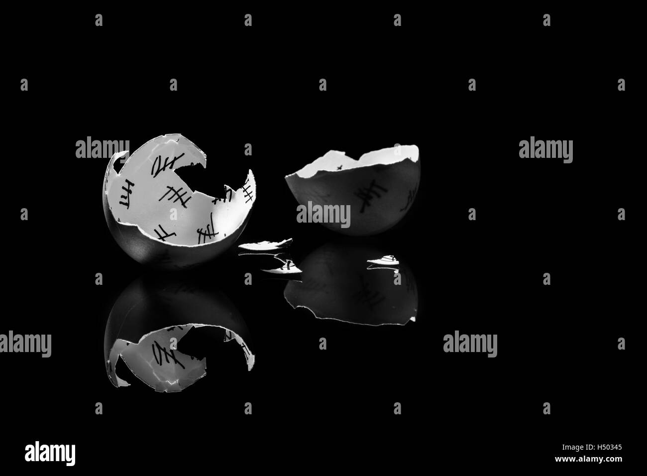cracked egg shell with countdown on black background, monochrome Stock Photo