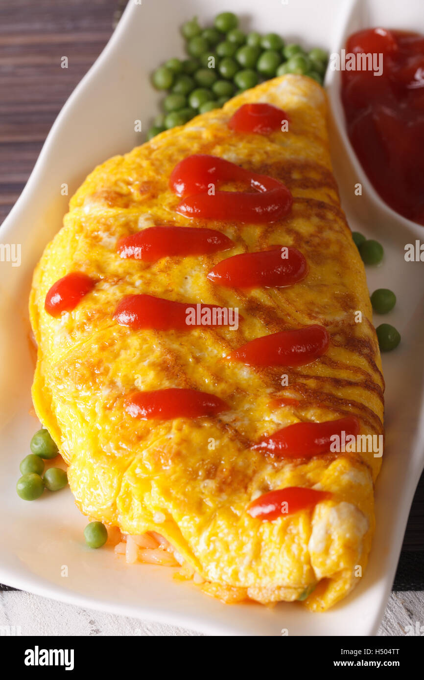 Delicious Omurice omelette with ketchup close-up on a plate. vertical Stock Photo