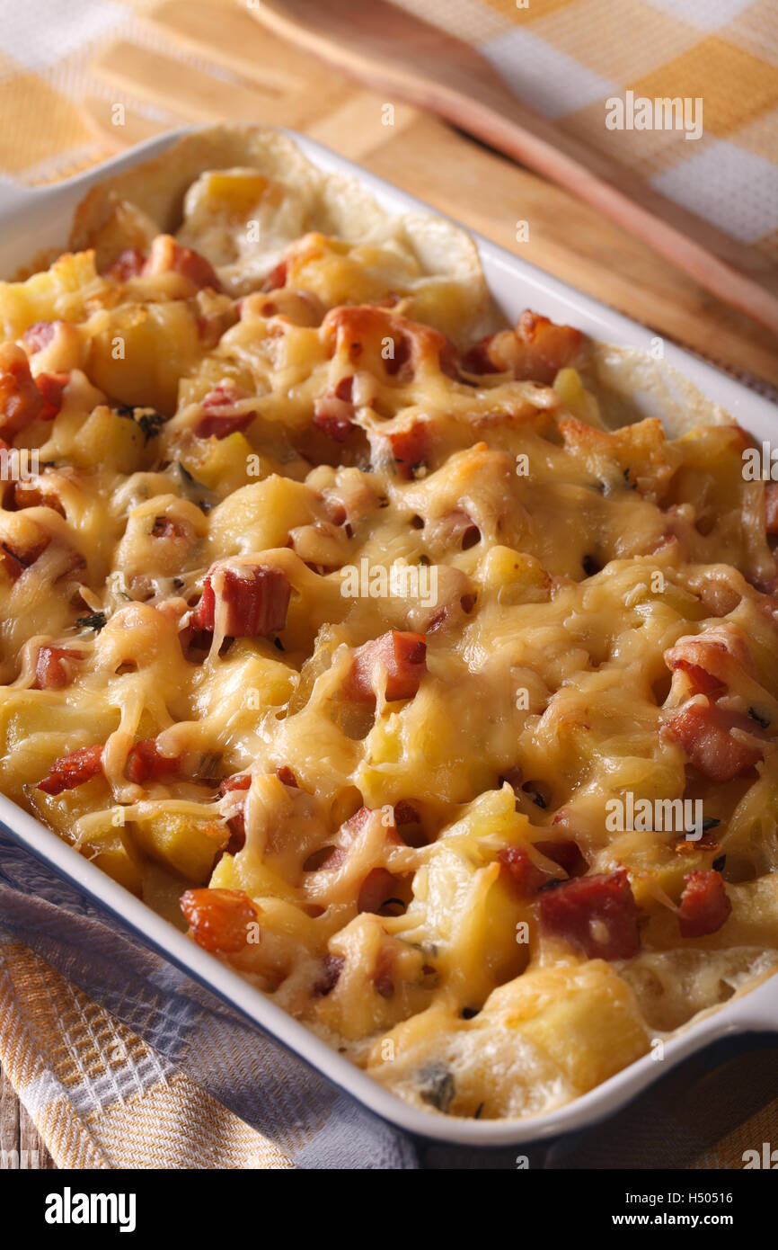 Baked potato with bacon and cheese close up in baking dish. vertical