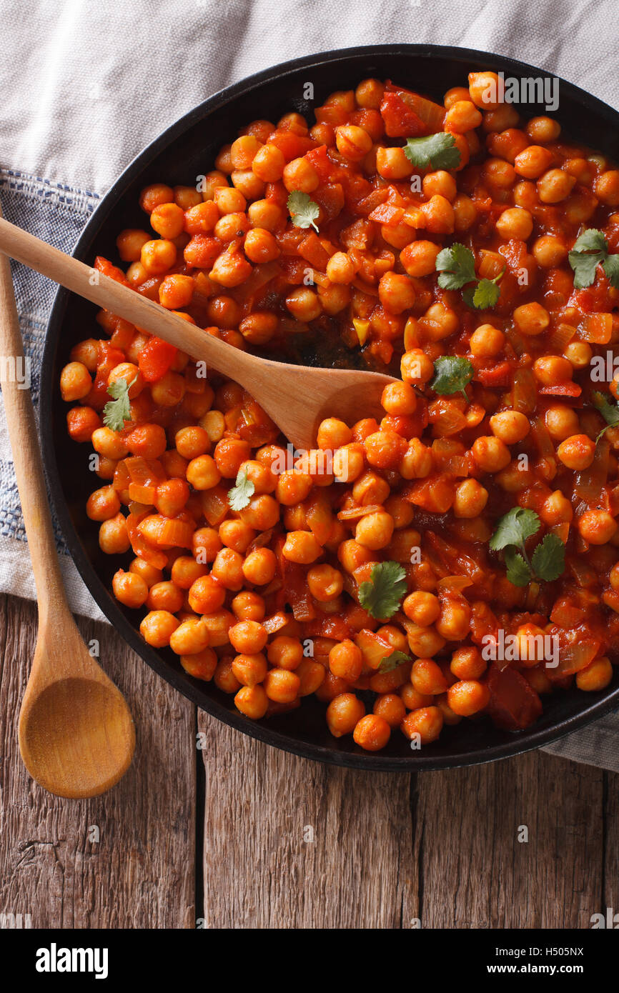 Indian Food chickpeas in curry sauce on a table closeup. Vertical top view Stock Photo Alamy