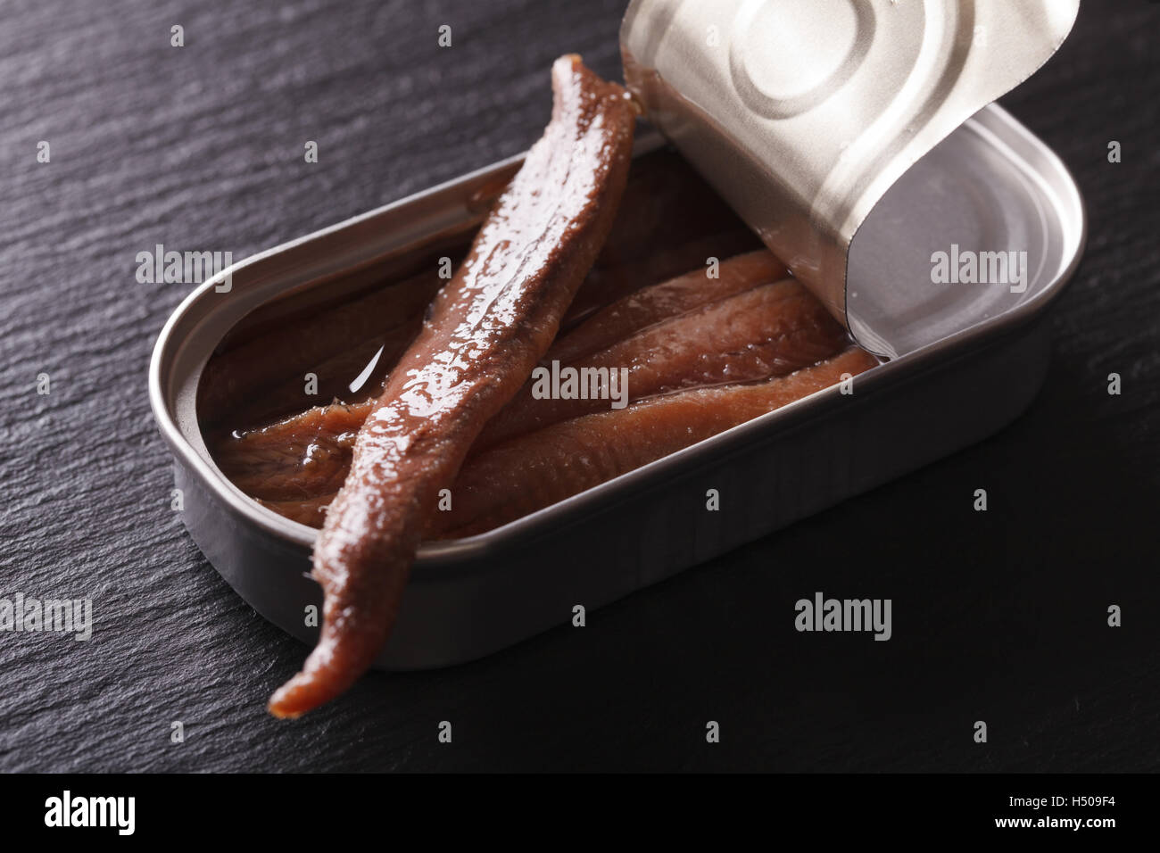 Anchovy fillets in tin macro on a slate board. Horizontal Stock Photo
