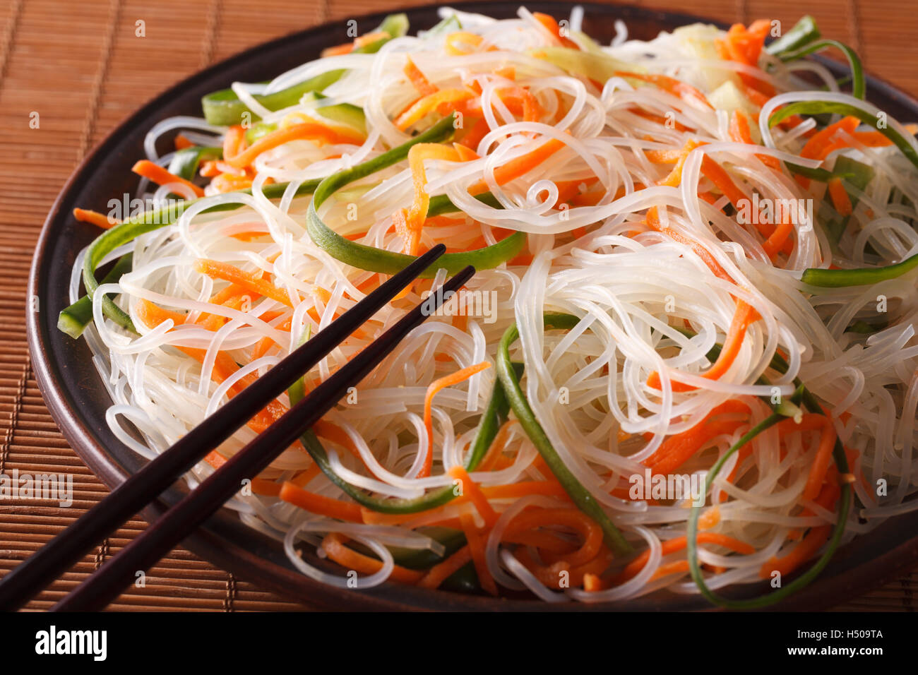 bean thread noodles salad with cucumber and carrot on a plate close-up. Horizontal Stock Photo
