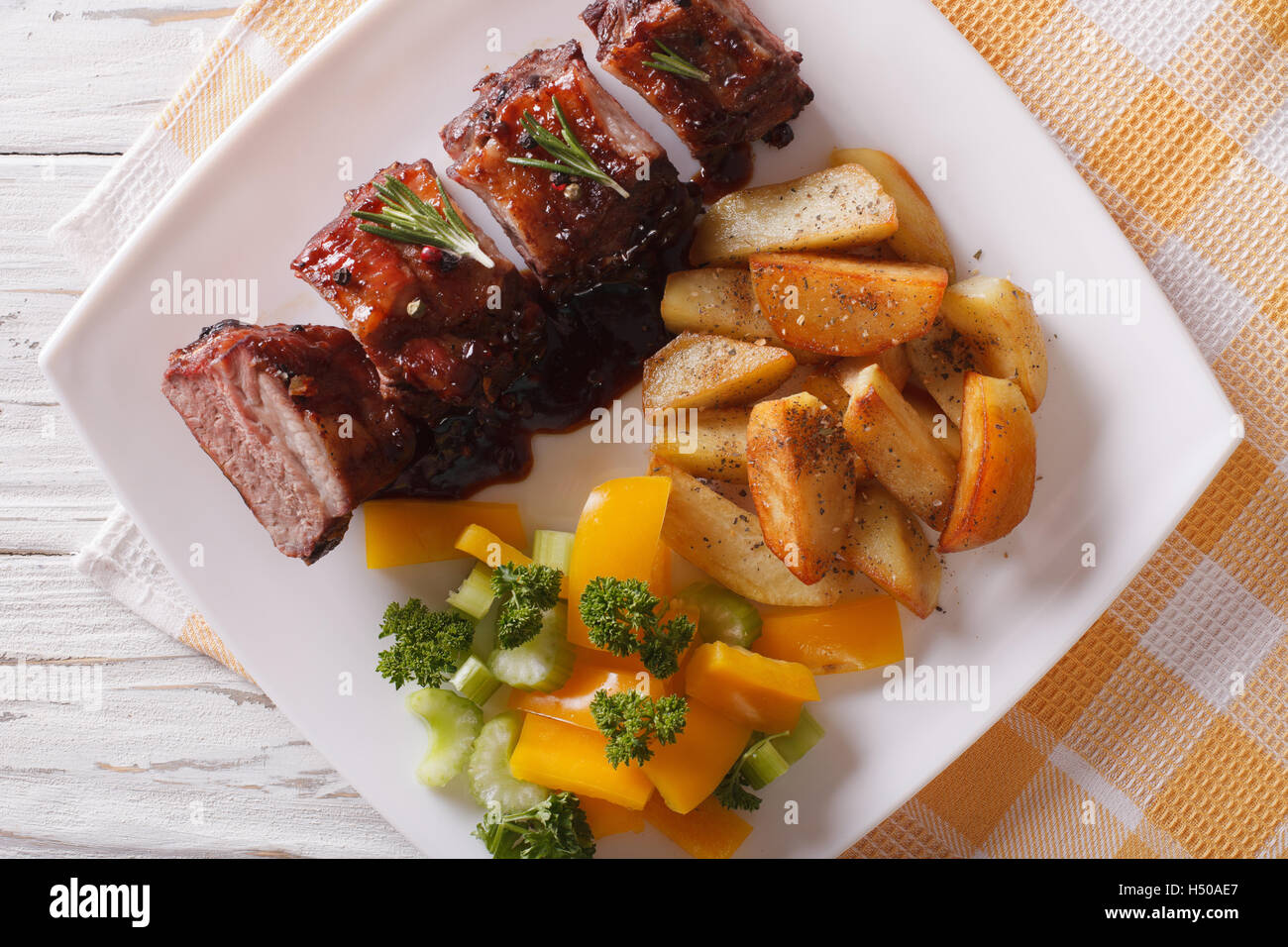BBQ pork ribs with potato and salad on the plate closeup. horizontal