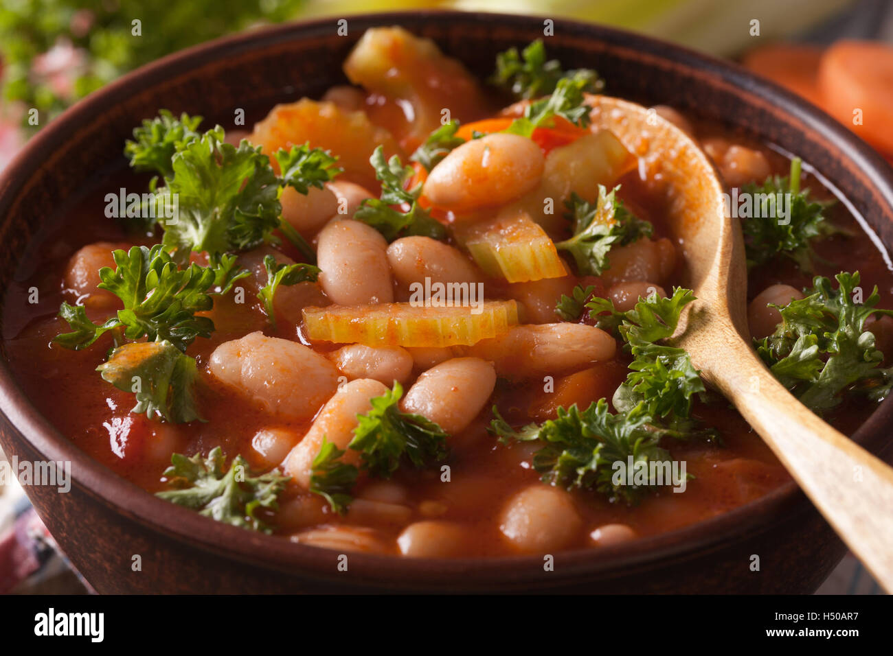 Bean soup with tomatoes and celery macro on the table. horizontal Stock Photo