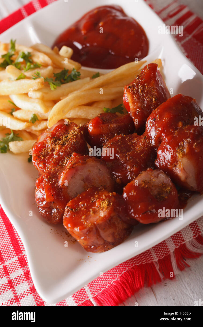 German cuisine: currywurst with french fries close-up on a plate. vertical Stock Photo