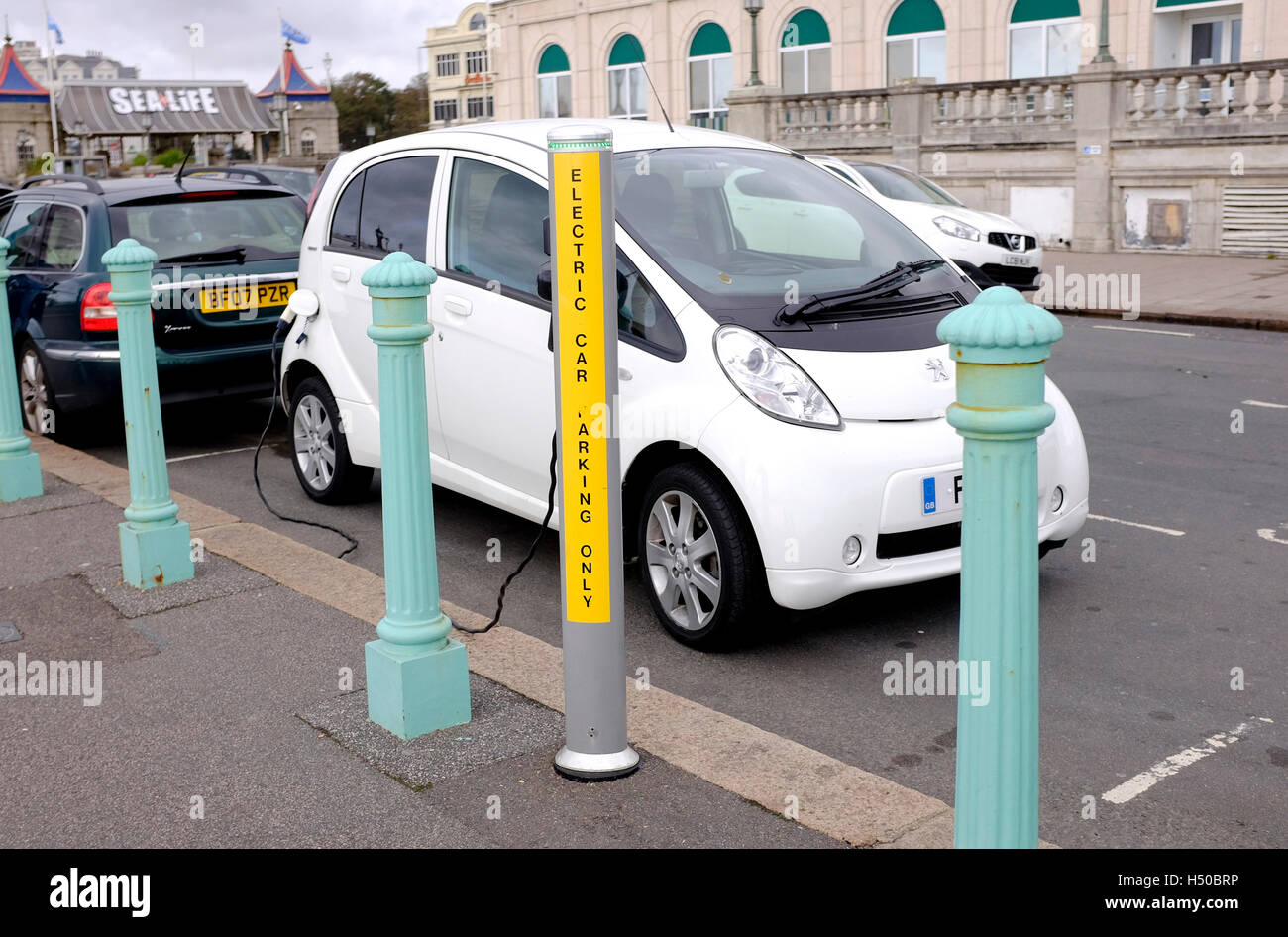 Peugeot car at an electric car charging point on Brighton seafront UK Stock Photo