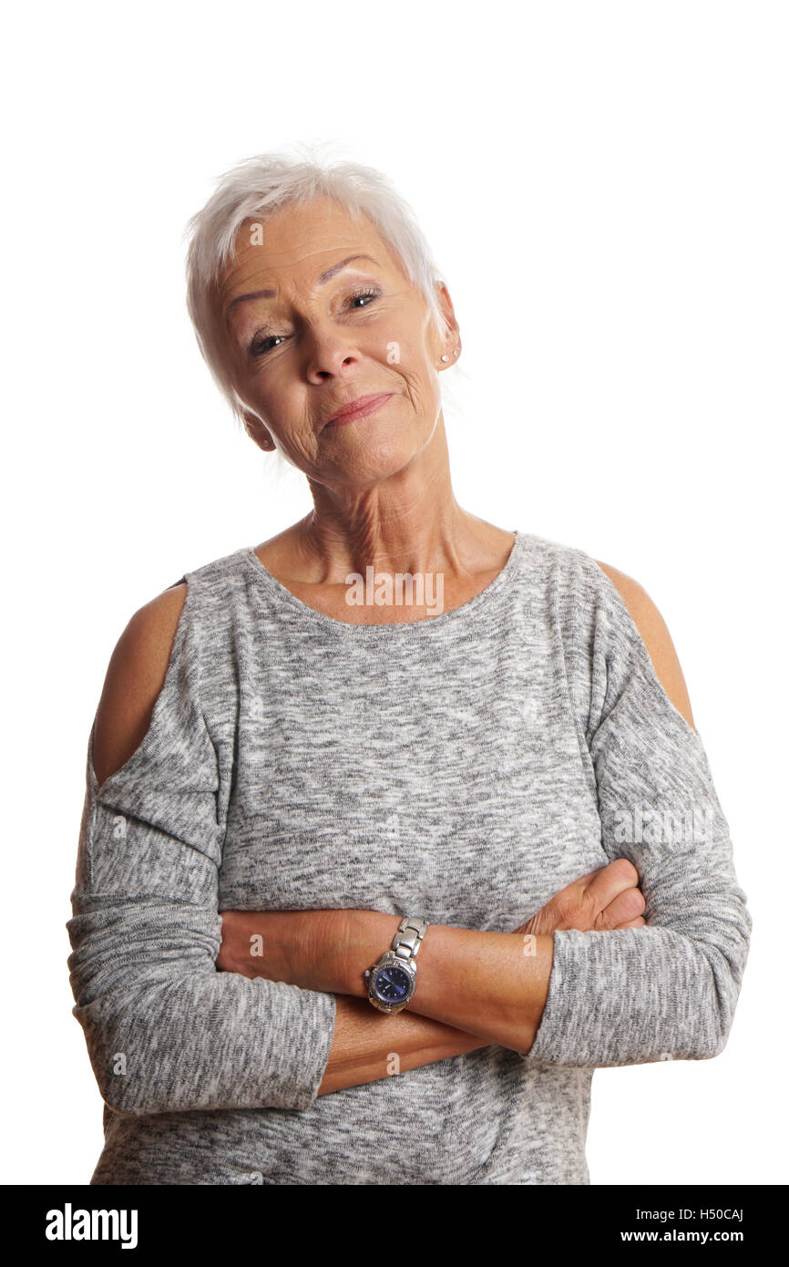 mature woman with arms folded and head tilted Stock Photo