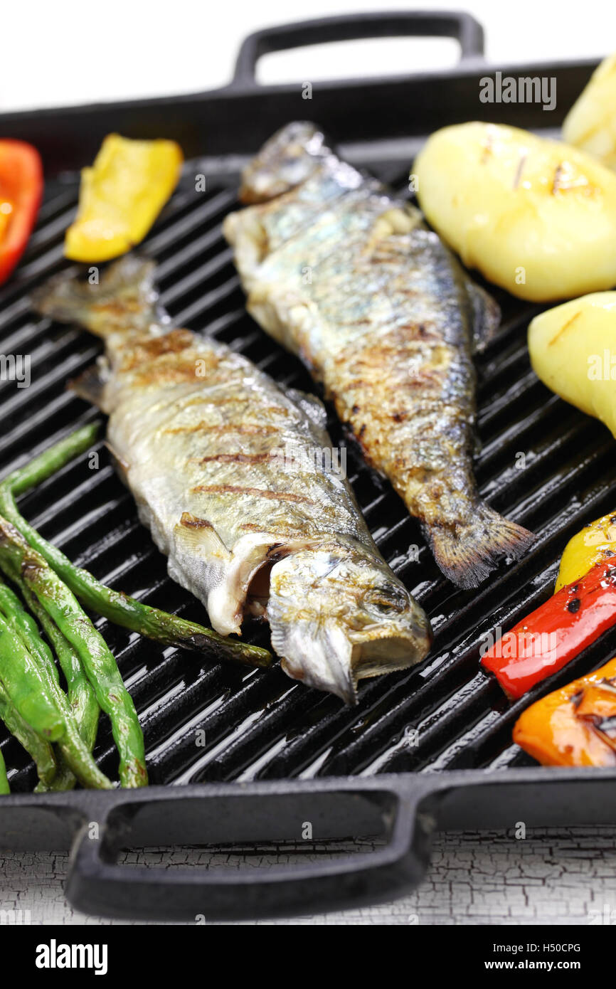 grilled whole rainbow trout with vegetables on grill pan Stock Photo
