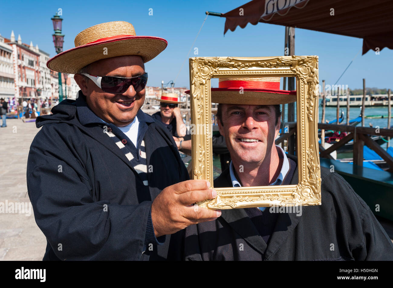 Two gondoliers having fun with picture frame in Venice Italy Stock Photo