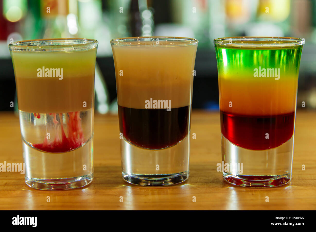 Several different alcohol multi colored shots in bar Stock Photo
