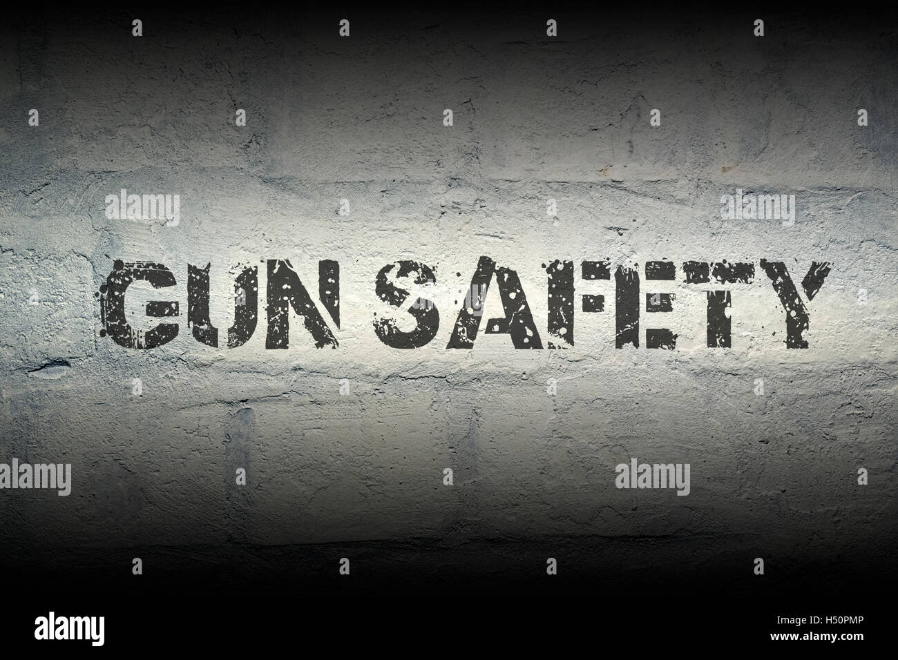 gun safety stencil print on the grunge white brick wall; specially