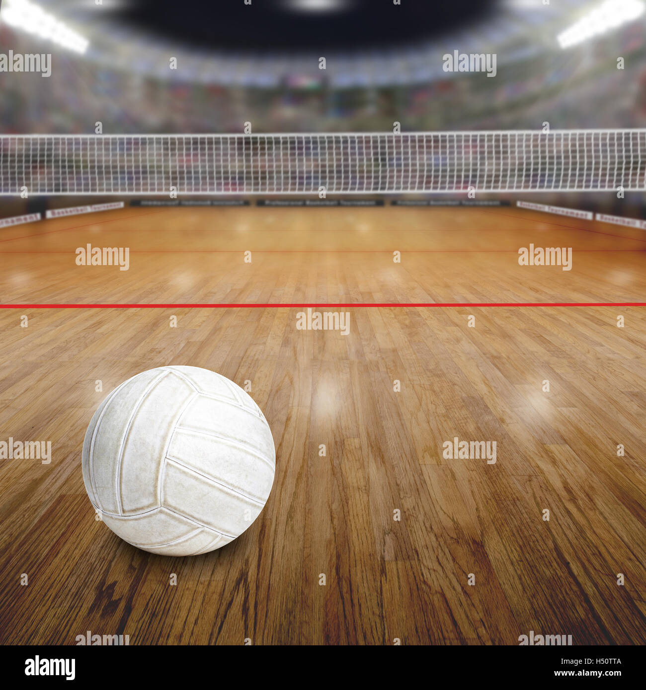 Sports arena full of fans in the stands with volleyball on wood flooring court. Deliberate focus on ball and shallow depth of fi Stock Photo