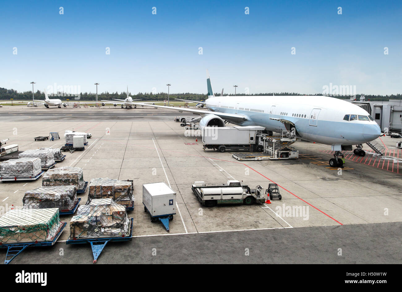 A commercial aircraft being serviced at the terminal of an international airport. Stock Photo