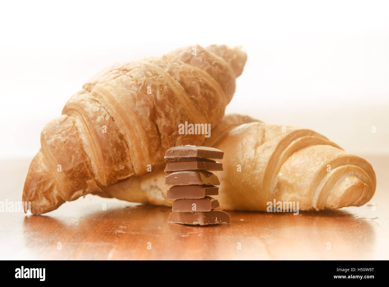 Two baked croissants with chocolate bars. Stock Photo