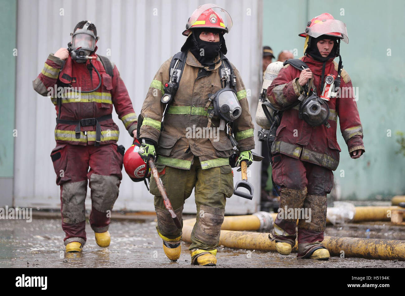 Lima, Peru. 19th Oct, 2016. Firefighters work at the site of a fire in a shoe factory in El Agustino district, in Lima, Peru, on Oct. 19, 2016. Three firefighters reportedly missing in a fire that started on Tuesday night at a shoe factory in Lima were found dead under the debris of the plant. © ANDINA/Xinhua/Alamy Live News Stock Photo