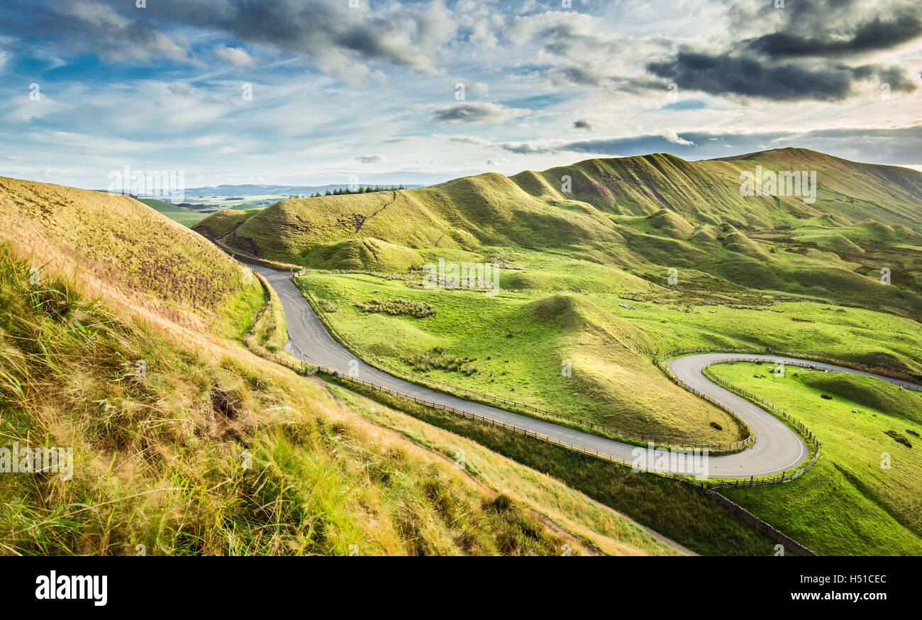 Empty Serpentine Road Among Green Hills of Peak District National Park in UK Stock Photo