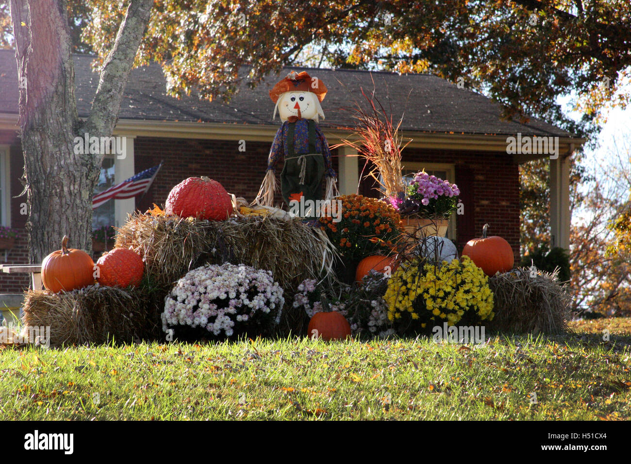 Outdoor Fall Decoration With Scarecrow Pumpkins Hay And Mums