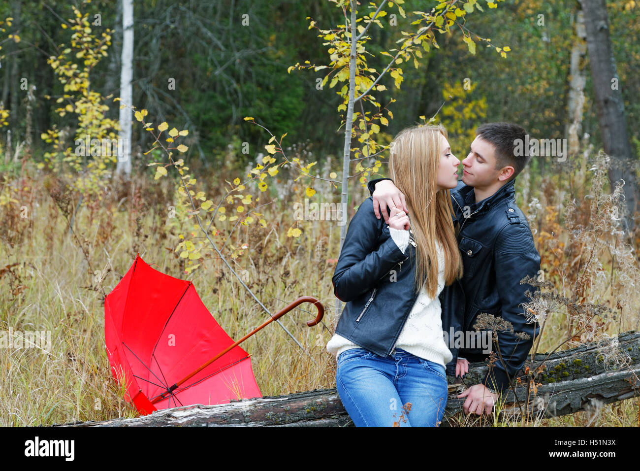 girl and a young man kissing in the woods Stock Photo