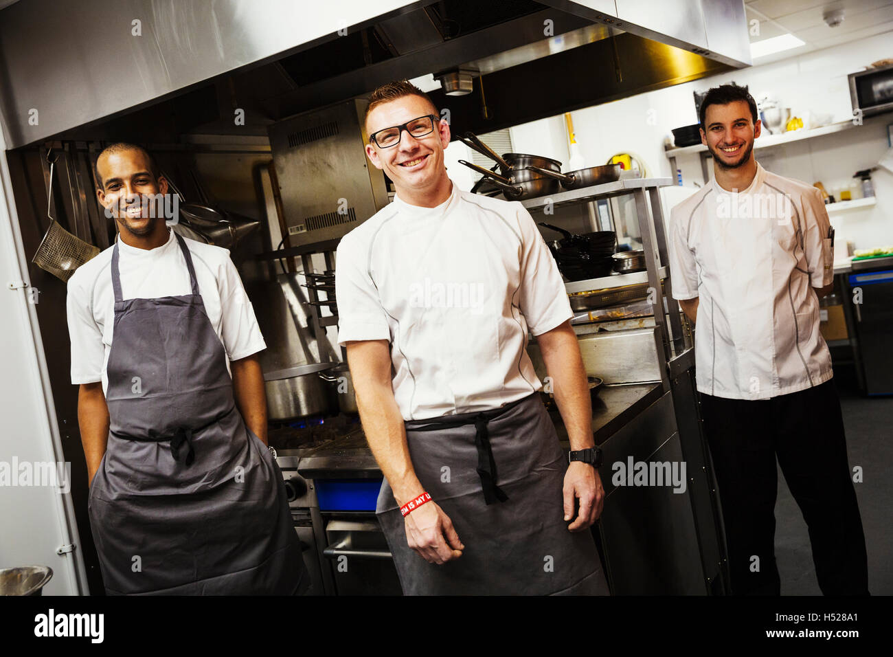 Portrait of three chefs in a restaurant kitchen. Stock Photo